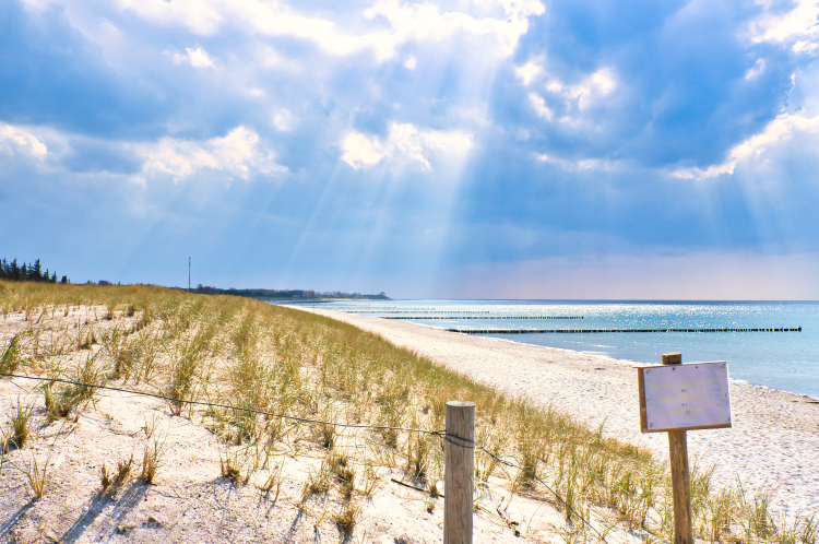 sun-rays-shining-through-thick-clouds-beach-baltic-seasign-beach-crossing-1 The phenomenon of wafers on the Baltic Sea: myths, legends, and historical accounts