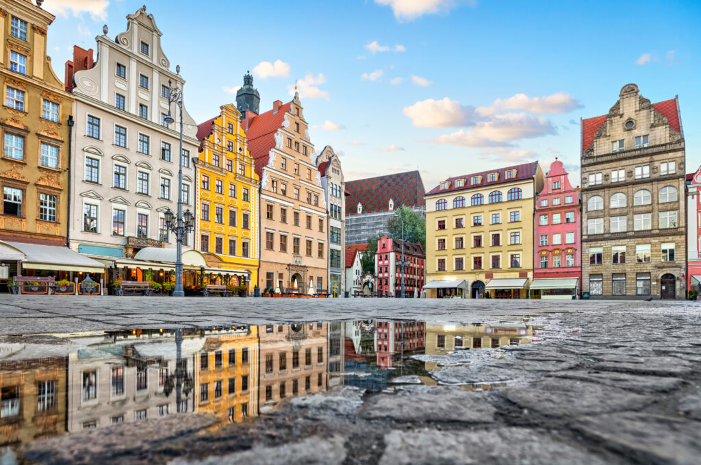 colorful-buildings-reflecting-puddle-rynek-square-wroclaw-1-1024x679 Wrocław: City of Enchanting Myths – Unveiling the Legend of the Bronze Dwarf