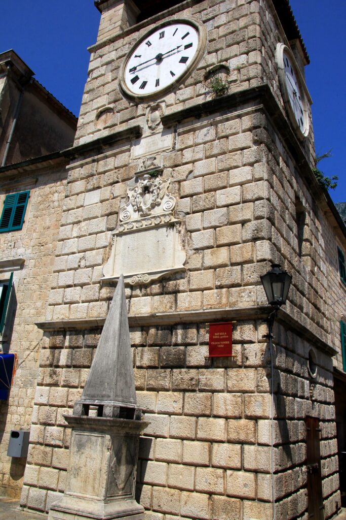 clock-tower-with-red-sign-front-it-683x1024 Kotor's Cat Kingdom: The Mysterious Cats of Montenegro, From Seafaring Legends to Cultural Icons