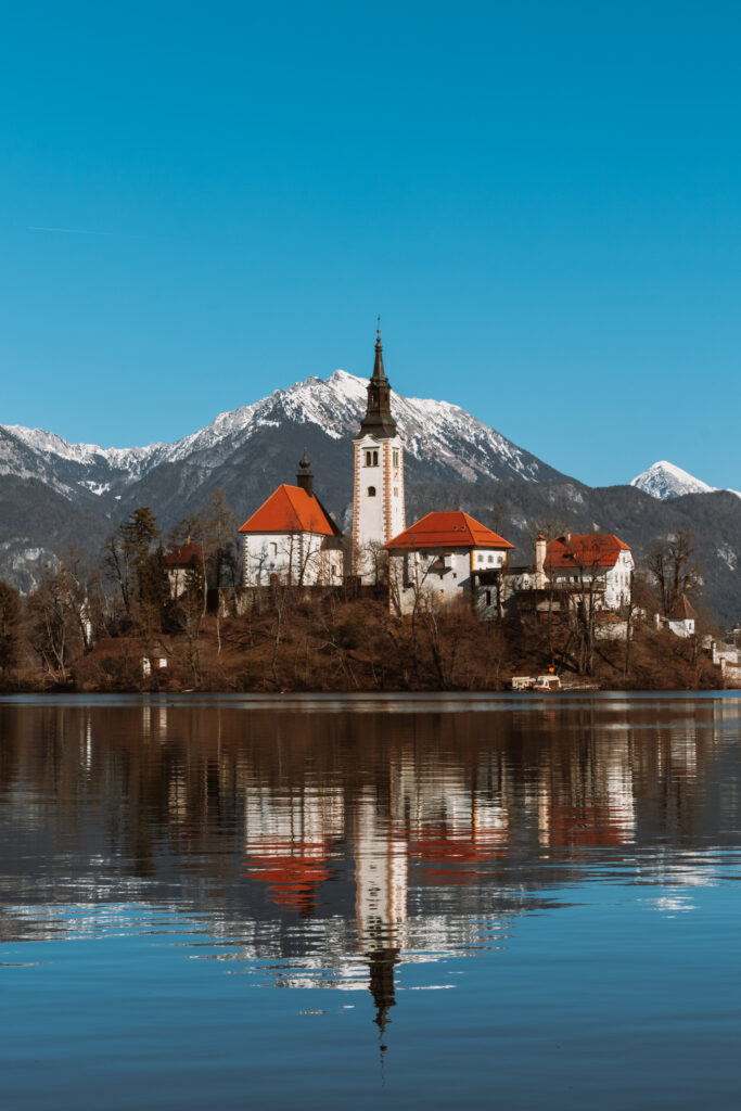 island-lake-against-clear-blue-sky-with-mountains-background-Kopie-683x1024 Mystical Bled: Discover the enchanting legends of Slovenia's famous island
